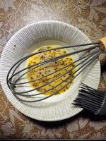 a whisk and a bowl of eggs photo