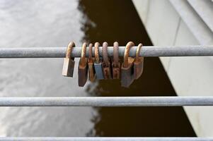 a group of four wooden locks on a metal railing photo