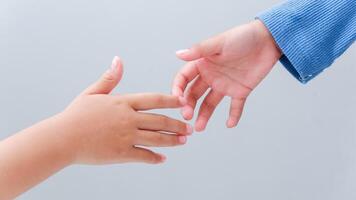 children hands reach toward each other isolated on gray. Small child's hand reaches for the hands friend. Helping hand concept, support. Helping hand outstretched. photo