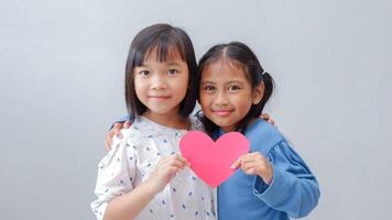 Cute little children with red hearts on grey background. Valentine's Day celebration. photo