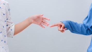 children hands reach toward each other isolated on gray. Small child's pointing for the hands friend. Helping hand concept, support. Helping hand outstretched. photo
