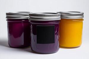 Three colorful glass jars with silver lids and blank label displaying vibrant jams or jellies photo