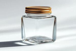 Empty square glass jar with golden lid on white background photo