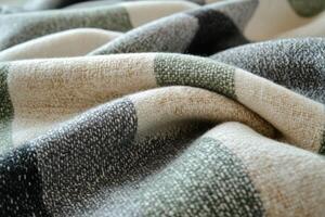 Soft plaid blanket with folds creating cozy texture ideal for background photo