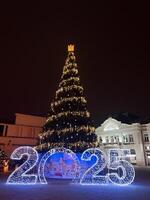Illuminated Christmas tree with 2025 decoration in a festive square photo
