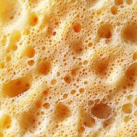 Texture of golden foam from a ripe cheese, highlighting bubbles and creamy surface during aging process photo