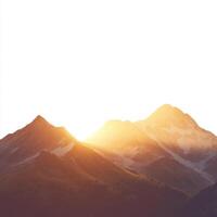 Sunrise over majestic mountains casting warm light on rugged peaks in a serene landscape photo