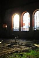 Spooky shot of chair in overgrown abandoned factory interior in backlight photo