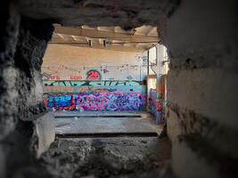 Hole in a brick wall in abandoned factory building photo
