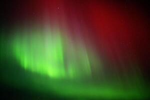Red and green aurora borealis on starry sky photo