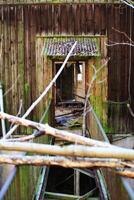 Damaged and blocked bridge leading into an abandoned building photo