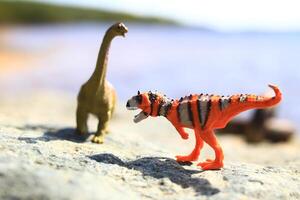 Two toy dinosaurs outside in a high key shot photo