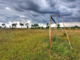 Abandoned soccer field under sky with stormclouds in Germany photo
