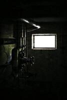Grungy image of pipes and valves in dark basement photo