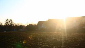Field and houses in defocused backlit shot photo