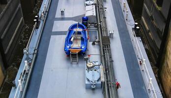 View on deck of inland barge with pipes and boat photo
