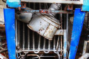 Detail of broken air filter of an old tractor photo