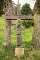 Ancient and weathered wooden cross on a cemetery in Germany, with an iron cross emblem photo