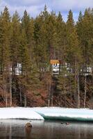 Wooden sign at icy shore with the Swedish word Kabel cable written on it photo