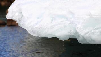 Detail of melting and dripping glacier above the water surface photo