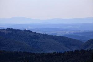Dense forest landscape overlooking Thuringian forest with layers of trees and distant horizon photo