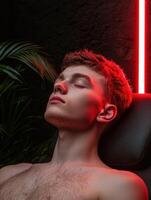 Young man relaxing in a chair under red light photo