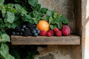 Fresh fruit and berries on rustic wooden shelf photo