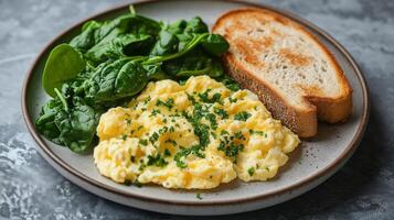 Scrambled eggs with toast and spinach served on a rustic plate for a healthy breakfast photo