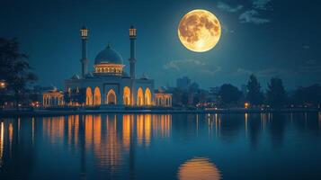 Majestic mosque illuminated at night under a full moon reflecting in water photo