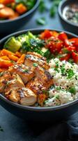 Grilled chicken bowl with vegetables and rice served in a black bowl photo