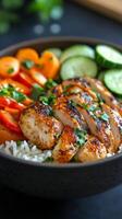 Grilled chicken bowl with vegetables and rice served in a black bowl photo