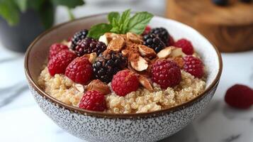 Quinoa bowl topped with berries and almonds served on a kitchen counter photo