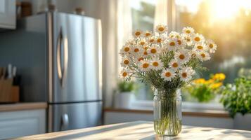 Bright kitchen with daisies in a vase and afternoon sunlight streaming through the window photo