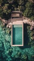 Beautiful cliffside swimming pool overlooking the ocean with clear blue water in a serene location photo
