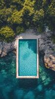 Beautiful cliffside swimming pool overlooking the ocean with clear blue water in a serene location photo