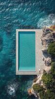 Beautiful cliffside swimming pool overlooking the ocean with clear blue water in a serene location photo