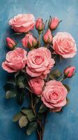 Beautiful bouquet of pink roses arranged against a bright blue background photo