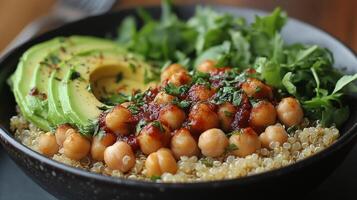 Bowl filled with quinoa, chickpeas, avocado, and fresh herbs set on a rustic table photo