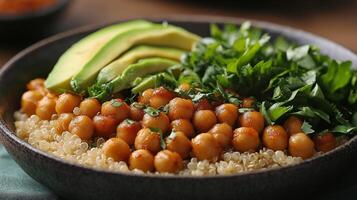 Bowl filled with quinoa, chickpeas, avocado, and fresh herbs set on a rustic table photo