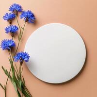 Blue flowers arranged around a white circle on a warm orange background photo