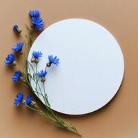 Blue flowers arranged around a white circle on a warm orange background photo