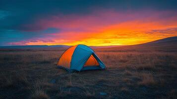 Bright yellow tent stands alone at sunset on a vast open landscape photo