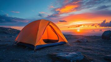 Bright yellow tent stands alone at sunset on a vast open landscape photo
