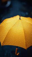 Bright yellow umbrella covered in raindrops during a rainy day photo