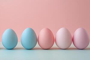Colorful pastel eggs arranged in a row on a light surface for festive decoration photo