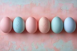 Colorful pastel eggs arranged in a row on a light surface for festive decoration photo