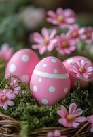 Colorful pink decorated eggs placed in a natural basket with flowers and greenery photo