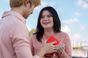 Valentine surprise couple celebrates love with gift outdoor setting emotional connection joyful moment photo