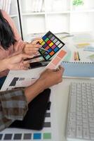 Creative design team collaborates on graphic color selection in modern office space photo
