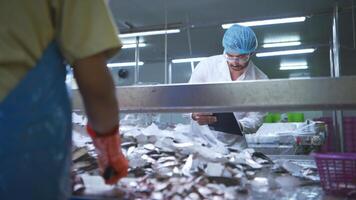 Raw material quality inspectors evaluate and inspect fish pieces before they enter the canned fish production process photo